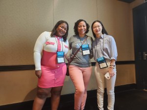 Photo of three women learning design scholars standing together at a conference. 