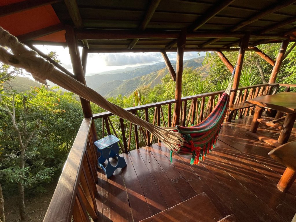 cabin balcony with a hammock overlooking the Costa Rican mountains and countryside
