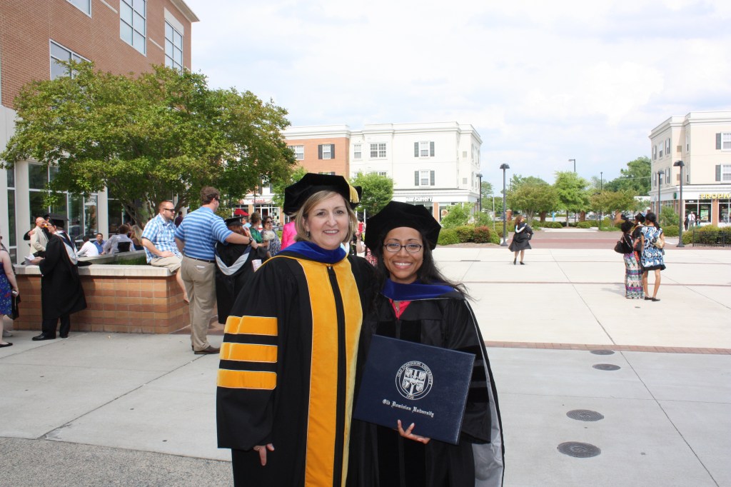 Doctoral advisor and a scholar who recently received her Ph.D. In their academic regalia.
